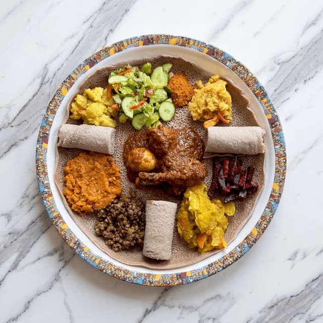 Ethiopian injera platter multiple stews overhead doro wat shiro gomen — injera platter hero photography