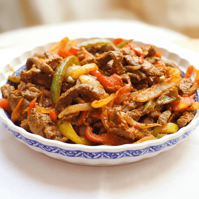 Ethiopian tibs beef cubes sauteed peppers onion sizzle clay dish — tibs hero photography