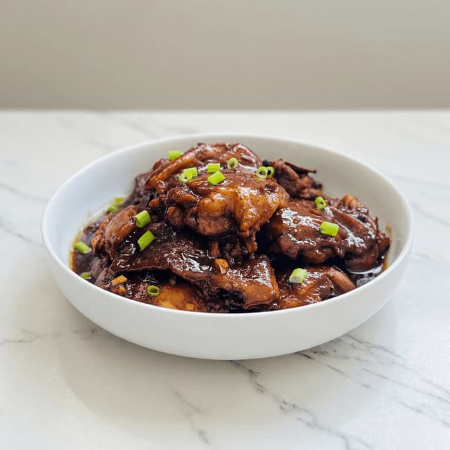 Chicken adobo filipino soy vinegar braise glossy glaze garlic bay leaf rice plate — adobo hero photography