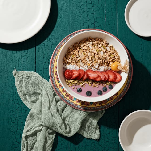 Vibrant pitaya dragon fruit smoothie bowl with tropical toppings — overhead flat-lay food content photography