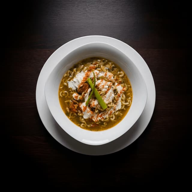 Golden khao soi curry noodle soup with crispy noodle crown — Northern Thai food photography
