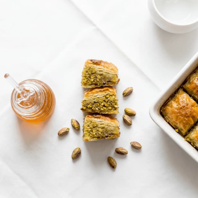 Baklava diamond phyllo layers pistachio honey syrup walnut tray macro — baklava hero photography