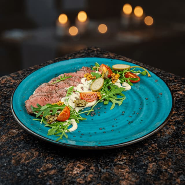 Wagyu beef tataki with yuzu ponzu on matte black plate — Japanese hotel restaurant menu photography
