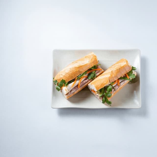 Banh mi-sandwich i tværsnit med paté, svinekød, syltede grøntsager, koriander, jalapeño og baguette, Houston — banh mi-hero-fotografering