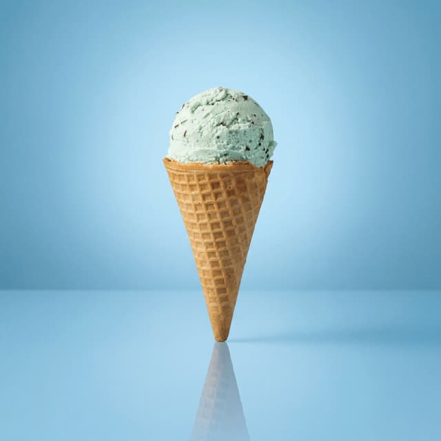 Mint chocolate chip ice cream waffle cone solo scoop — clean cone presentation card photography
