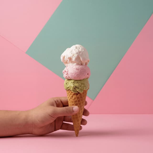 Triple-scoop ice cream tower on waffle cone — pistachio strawberry vanilla bean — scoop shop hero photography
