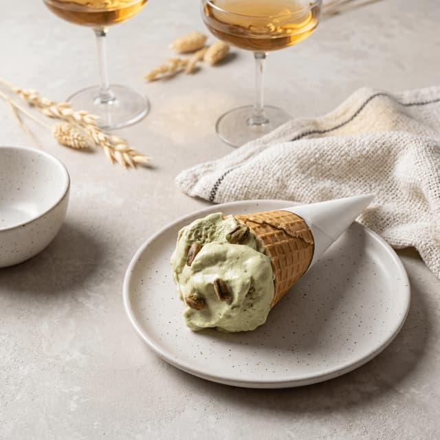 Pistachio gelato single scoop waffle cone Italian gelateria — artisan green nut dessert hero