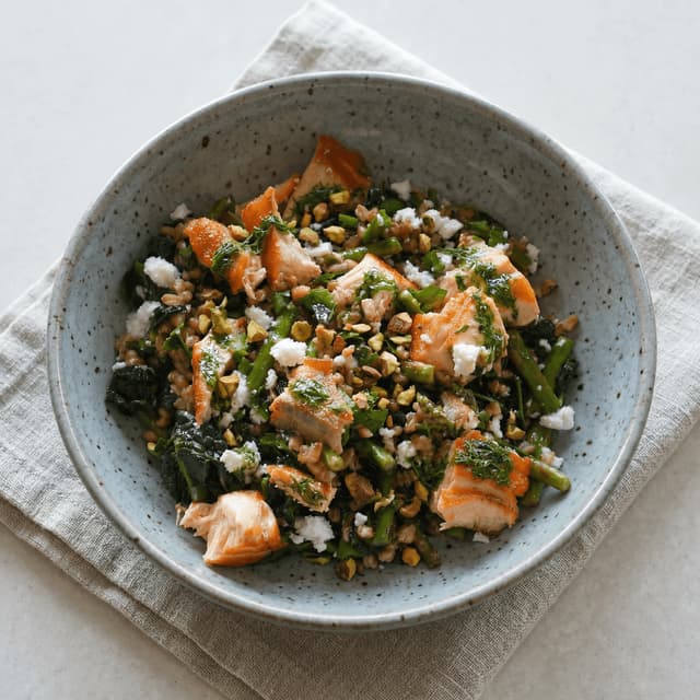 Mediterranean wellness bowl salmon greens farro avocado nuts overhead marble — wellness bowl hero photography