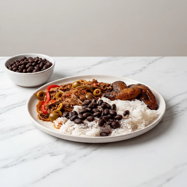 Ropa vieja cuban shredded beef tomato peppers black beans rice plantains plate miami — ropa vieja hero photography