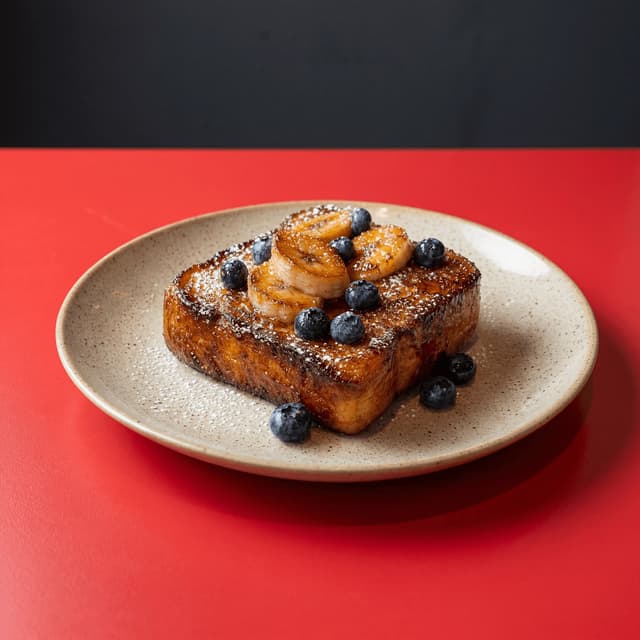 Grube tosty francuskie z brioche z karmelizowanym bananem i borówkami — fotografia kawiarni brunch