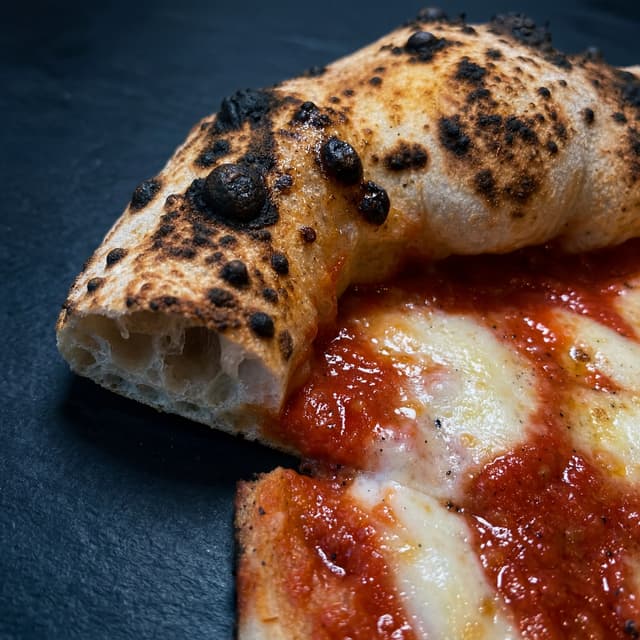 Macro en primer plano del cornicione napolitano con manchas de leopardo — fotografía de tarjeta de textura de corteza de pizza