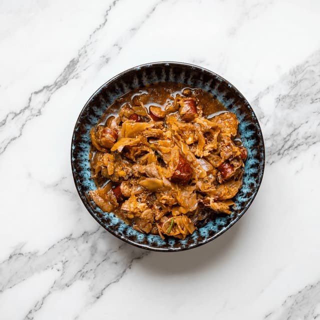 Bigos hunter stew sauerkraut meat mushroom rye bread overhead bowl — bigos hero photography
