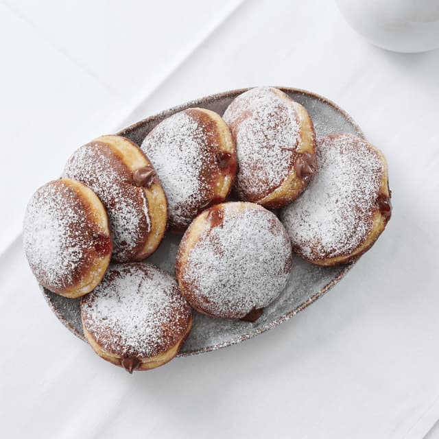 Paczki Polish filled donuts powdered sugar rose jam glaze tray — paczki hero photography
