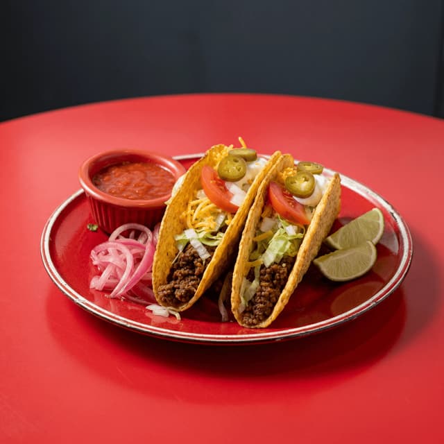 Three hard shell tacos lettuce cheese tomato red checkered Mexican cafe — hard shell card photography