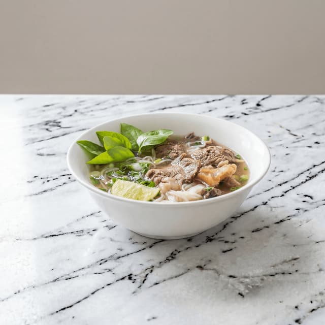 Pho bo beef noodle soup steam rising herbs bean sprouts lime jalapeno bowl — pho hero photography