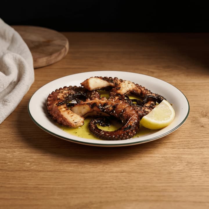 Greek grilled octopus tentacle char oregano lemon capers olive oil taverna plate macro — grilled octopus FAQ sidebar photography