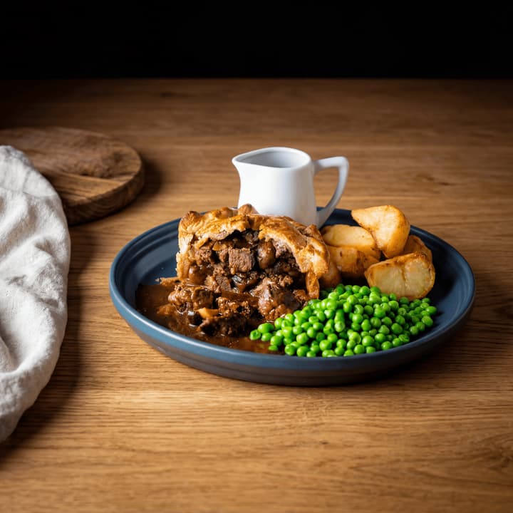 Steak & Ale Pie, goldene Kruste, aufgeschnitten, glänzende geschmorte Rindfleischfüllung, Kartoffelpüree, Gravy, Makro, Manchester Gastropub – Pie-FAQ-Sidebar-Fotografie