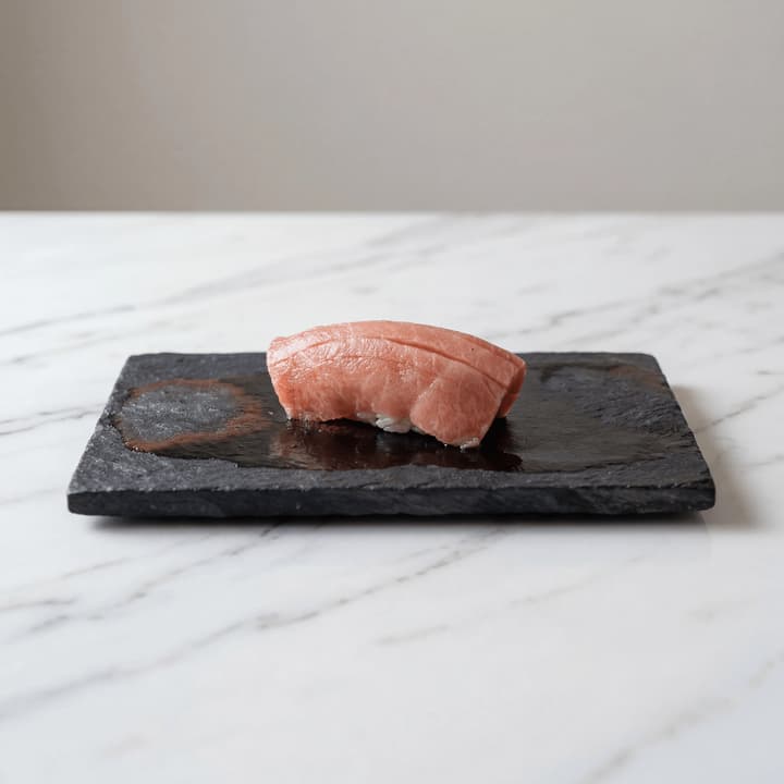 Single otoro nigiri macro slate plate brush nikiri glaze — iconic sushi FAQ sidebar photography