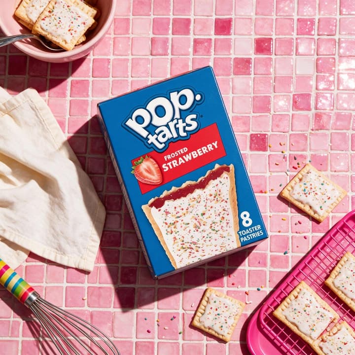 Toaster pastry box on glossy pink mosaic tile with pastries — playful packaged food photography by FoodShot AI