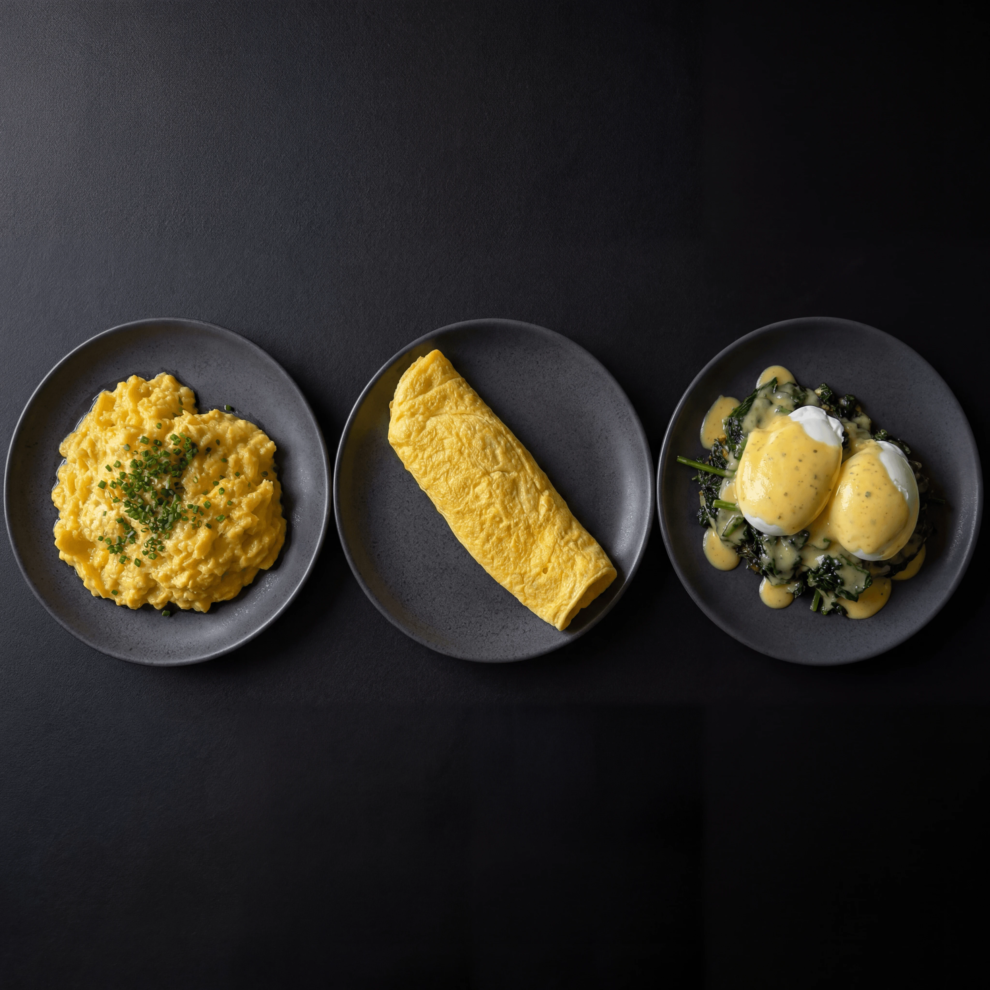 Three egg preparations scramble omelet poached dark monolith — egg dishes card photography