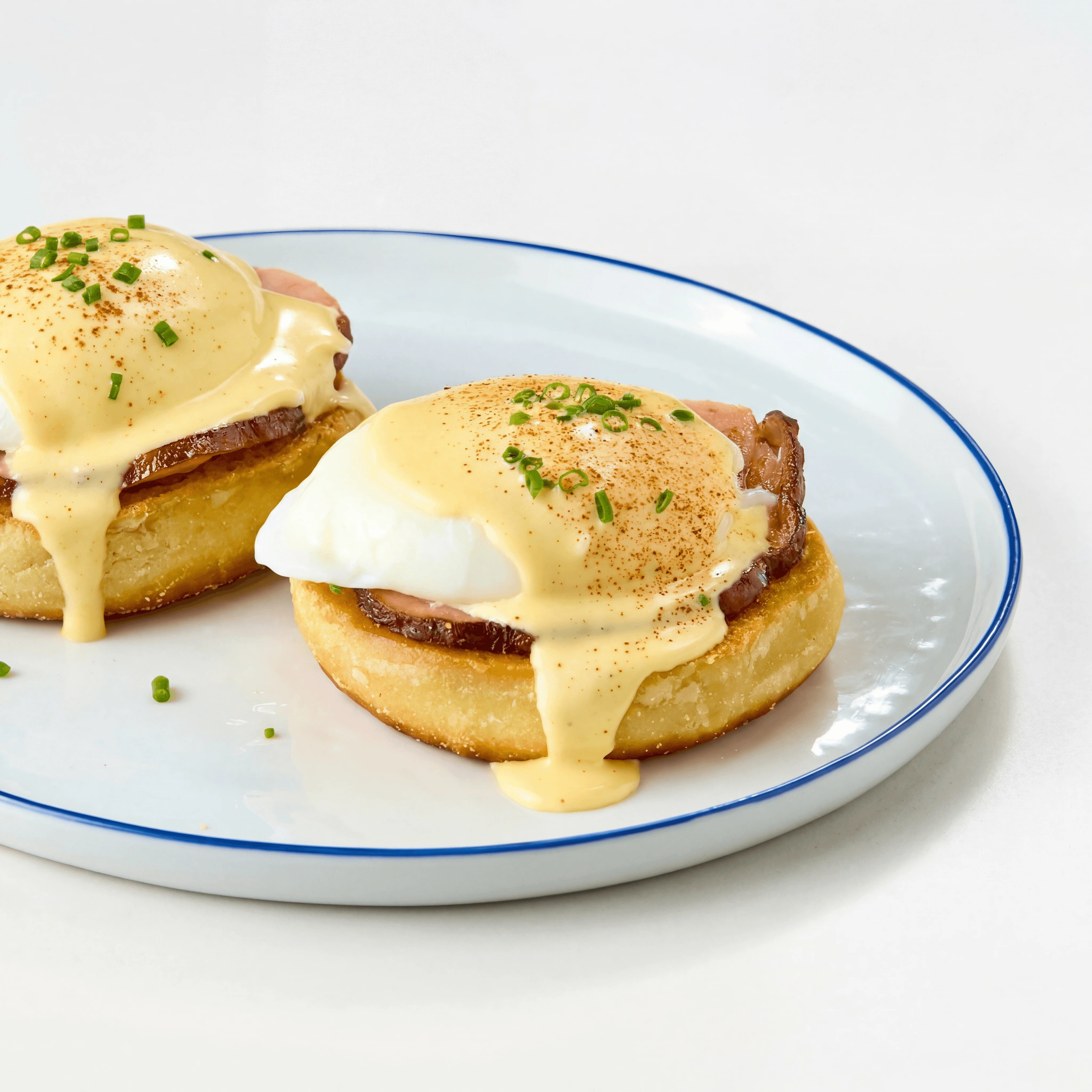 Eggs Benedict English muffin Canadian bacon hollandaise chive — eggs benedict hero photography