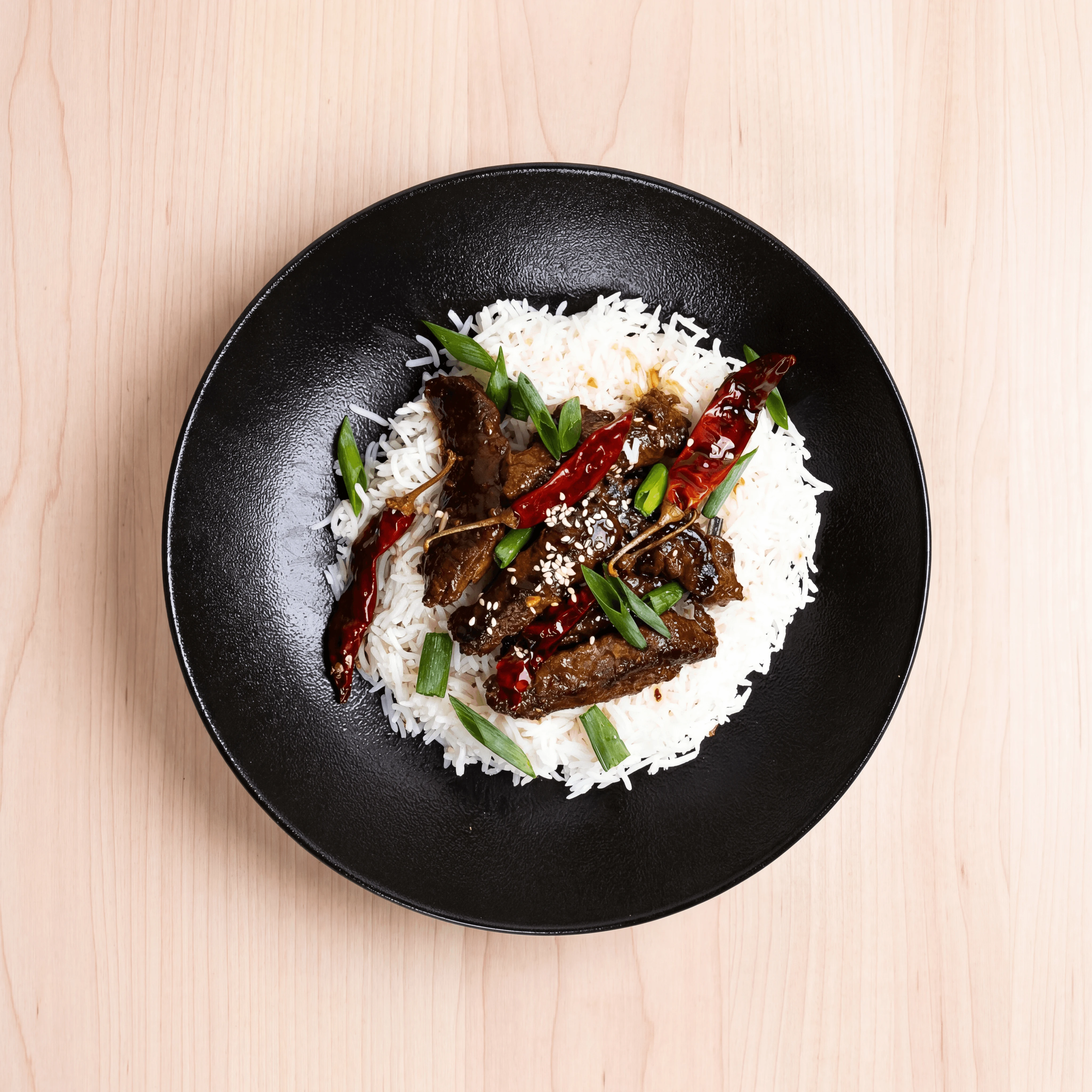 Korean dosirak lunch box with bulgogi, japchae, and banchan compartments — corporate catering photography