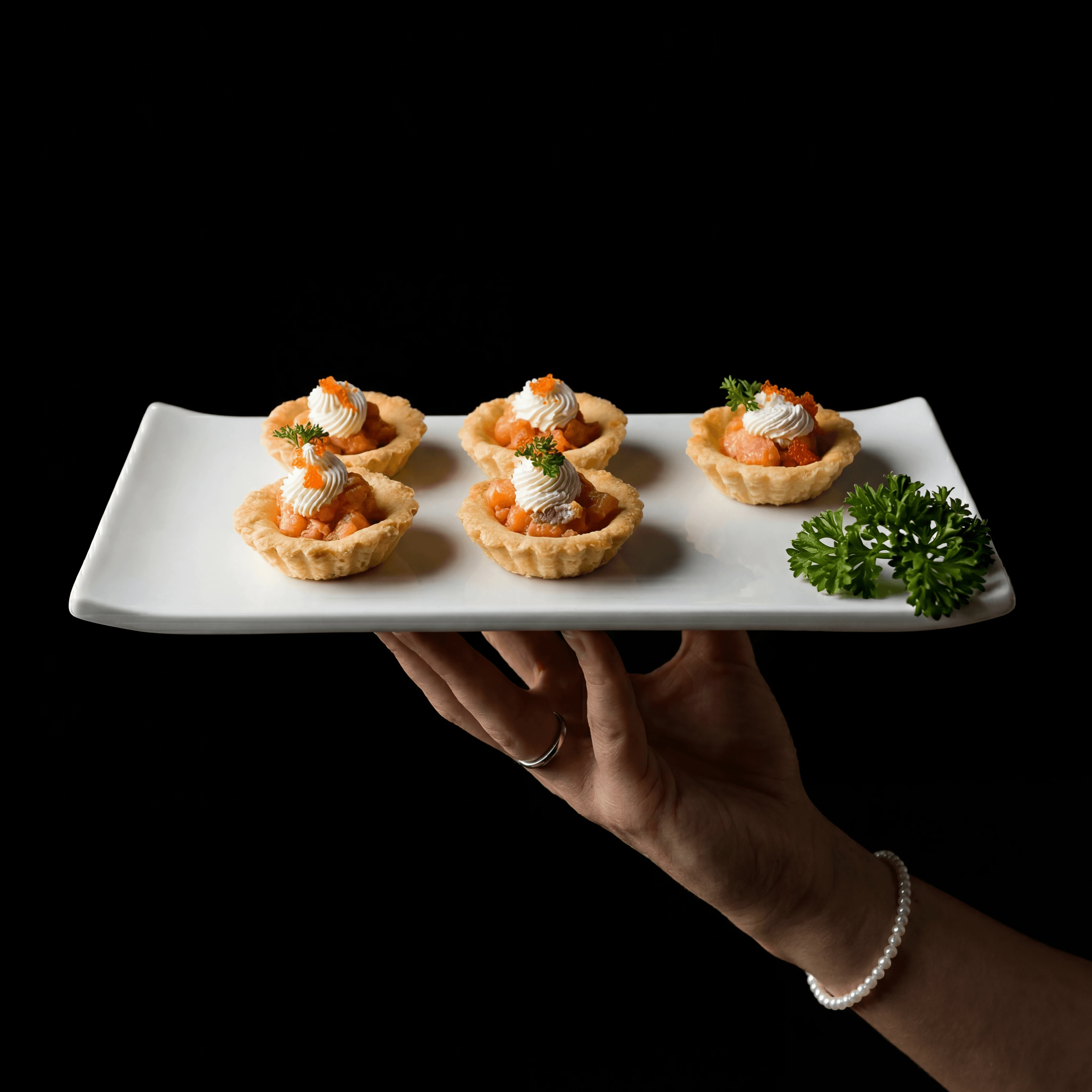 Smoked salmon blini canapés with caviar on black slate tray — cocktail hour appetizer catering photography