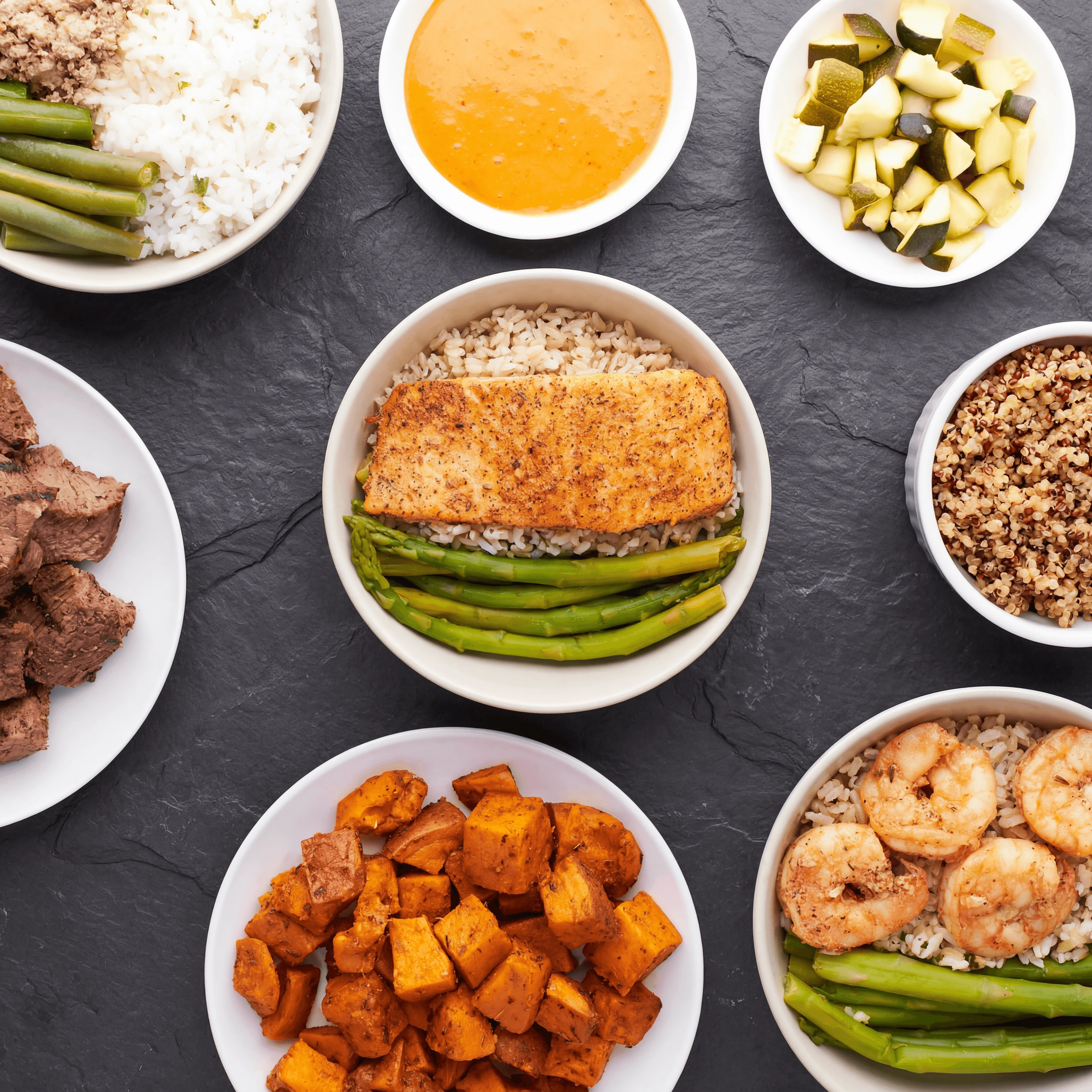 Japanese makunouchi bento box with compartments of sablefish, tamagoyaki, and rice — corporate catering photography