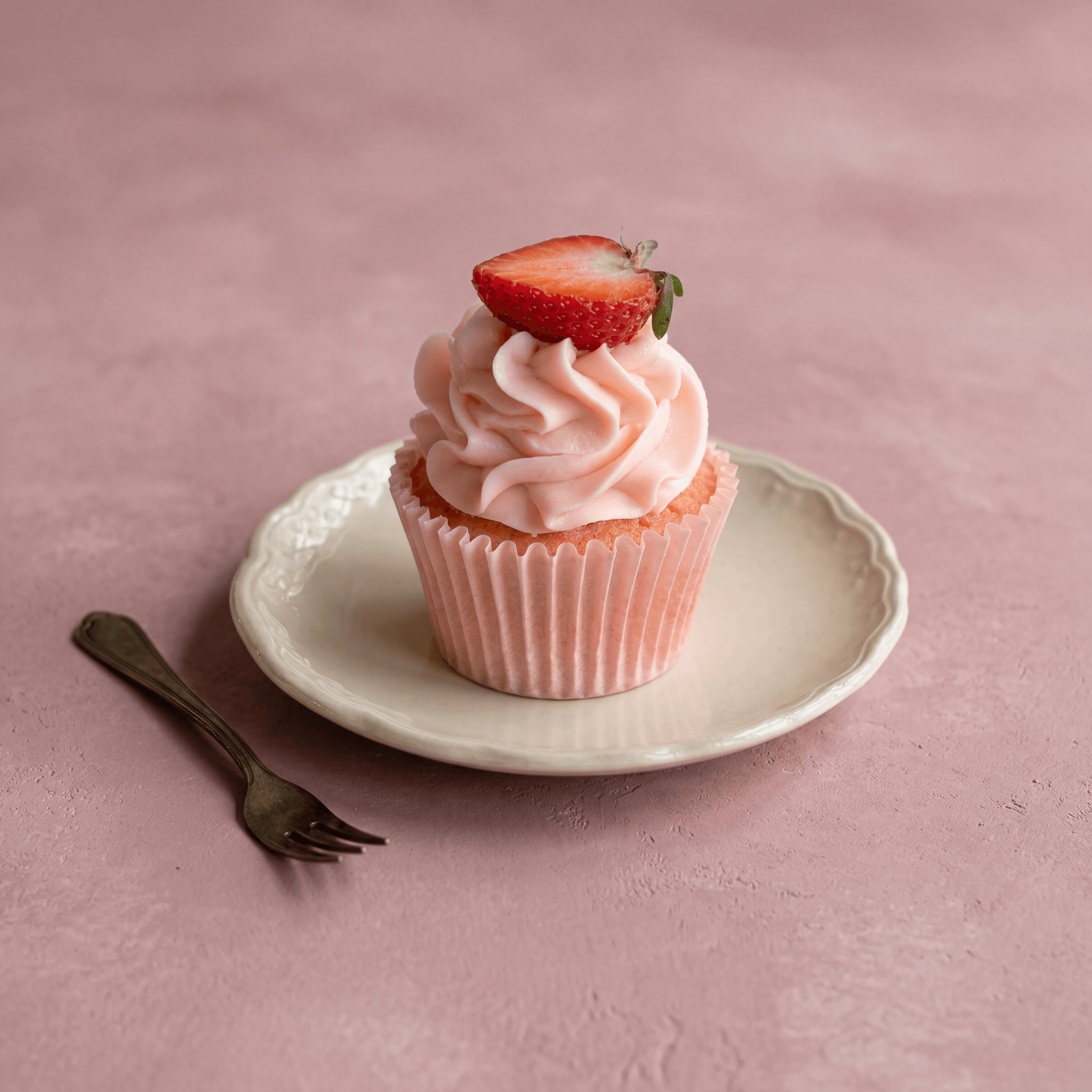 Strawberry shortcake cupcake with pink swirl and fresh berry — wedding cupcake photography