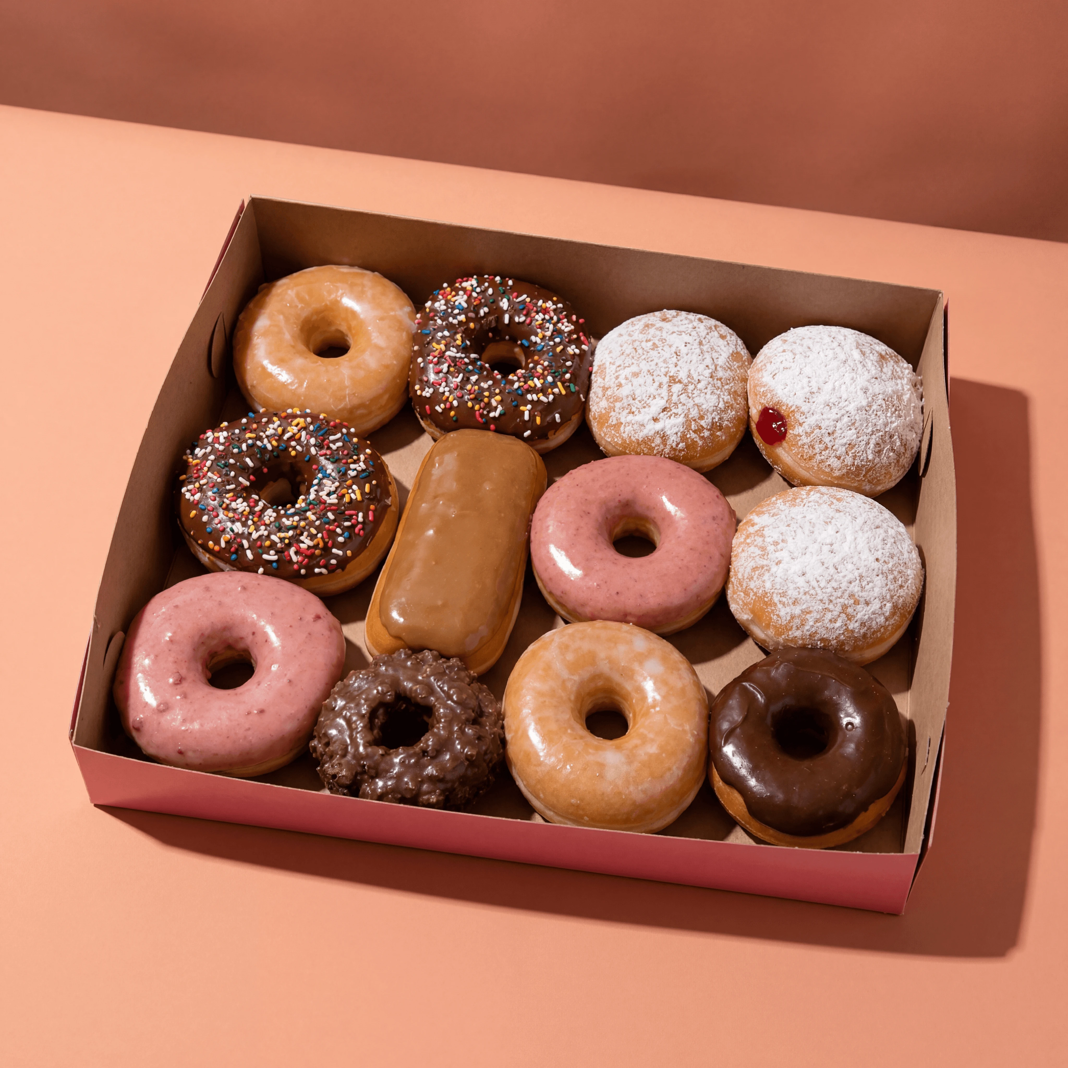 Pink box twelve donuts open assortment Voodoo — boxed dozen card photography