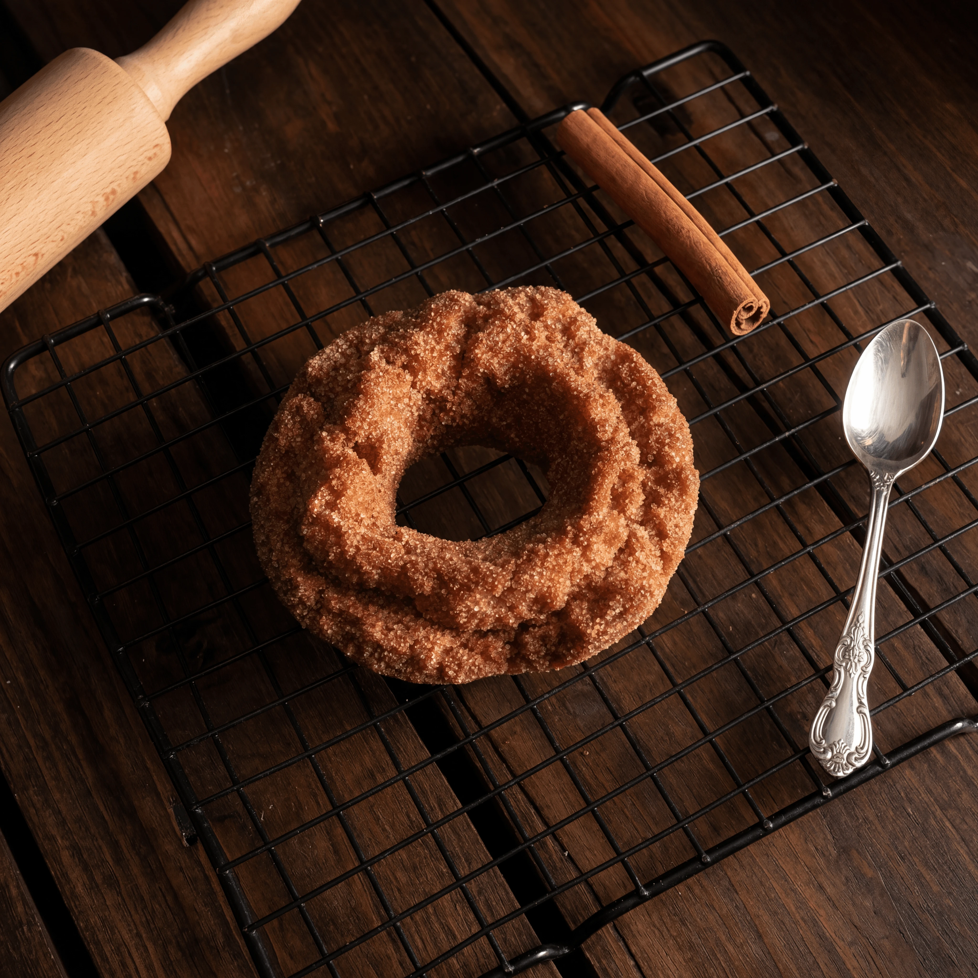Old fashioned cake donut cinnamon sugar coating cooling rack — classic donut hero photography