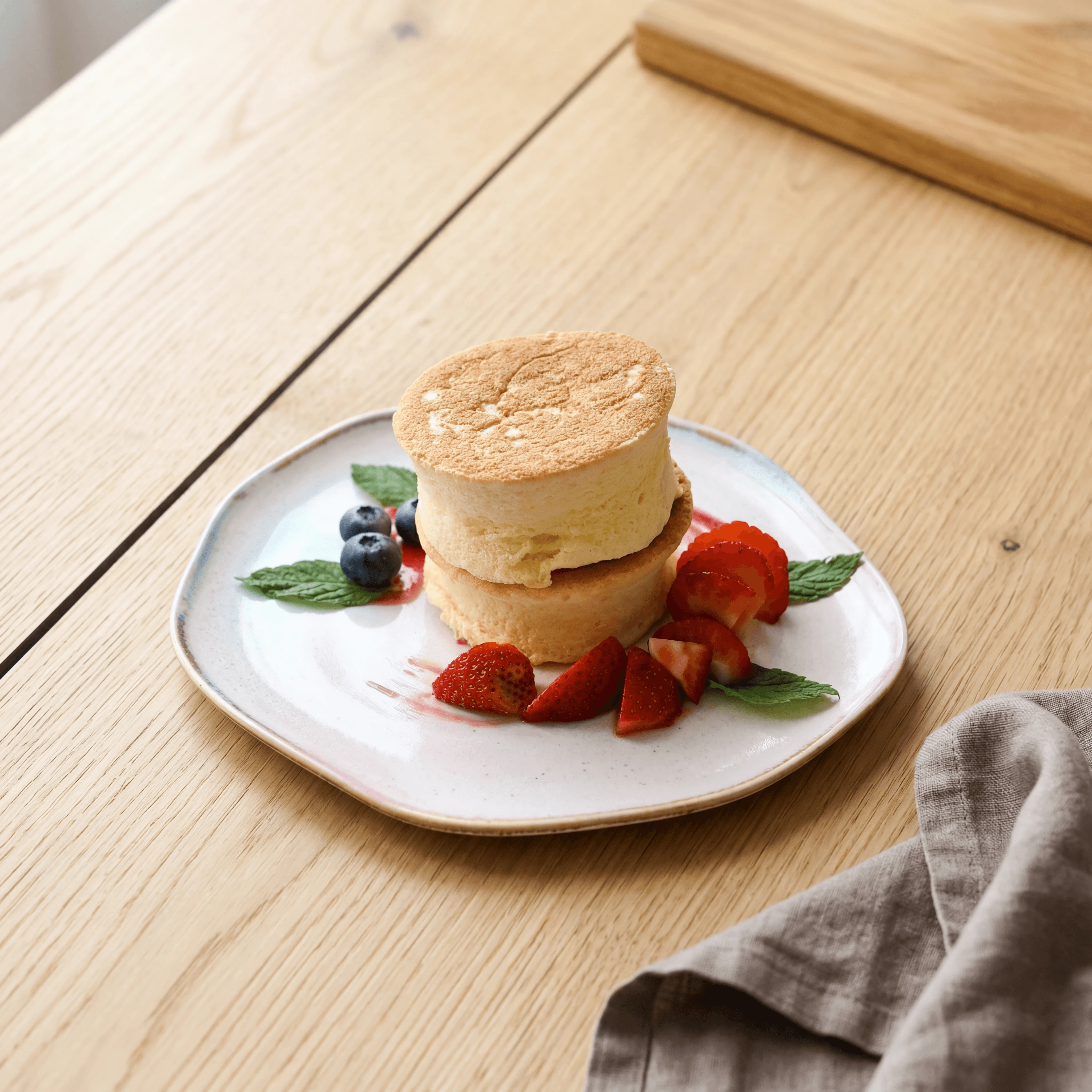 Fluffy Japanese soufflé pancakes stacked with fresh strawberries and vanilla ice cream — brunch content photography