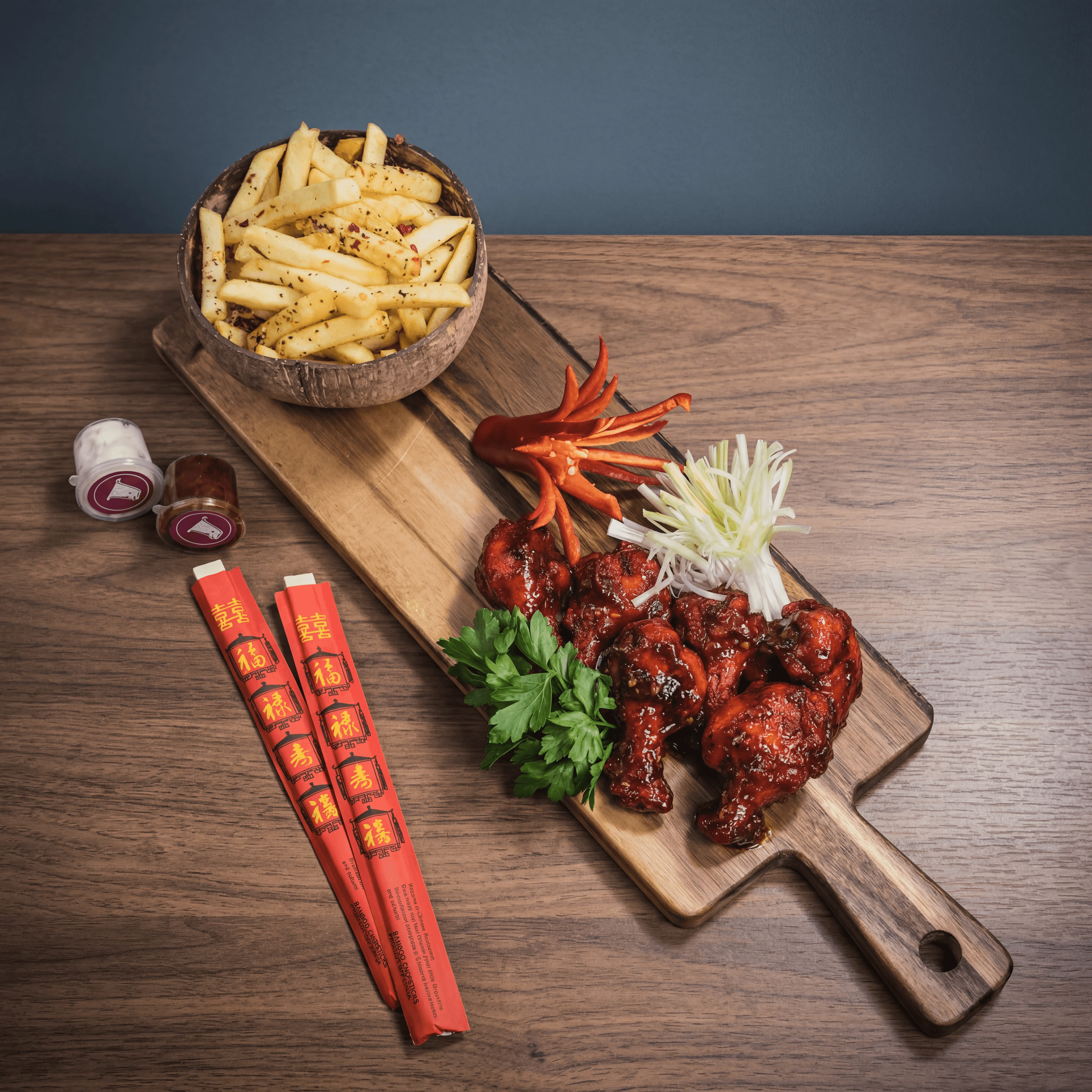 Korean gochujang-glazed fried chicken wings with fries on wood board — ghost kitchen chicken brand photography