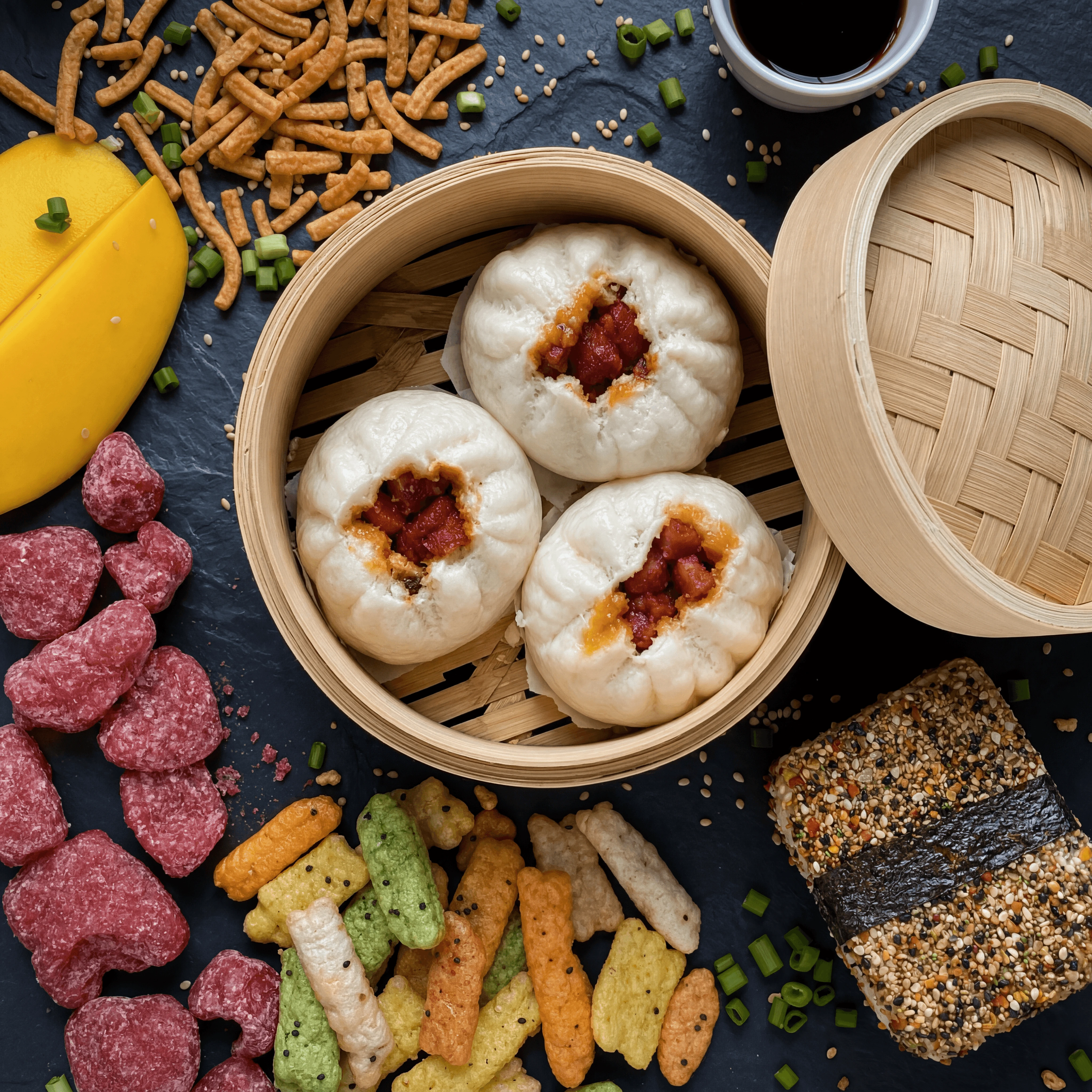 Manapua steamed buns mochi crunch snacks dark slate top down Hawaiian — manapua snacks card photography