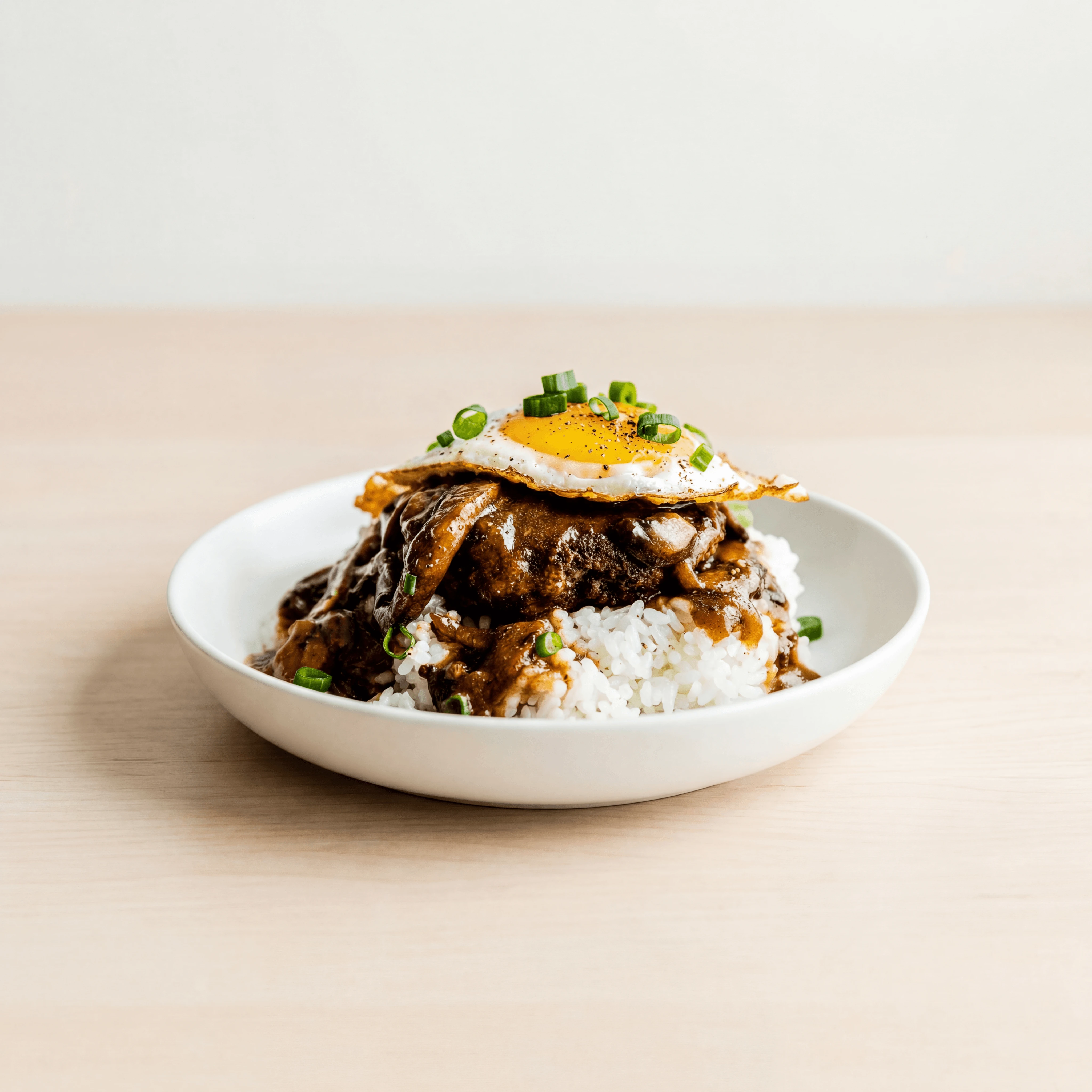 Loco moco rice hamburger patty egg gravy plate light wood — loco moco hero photography