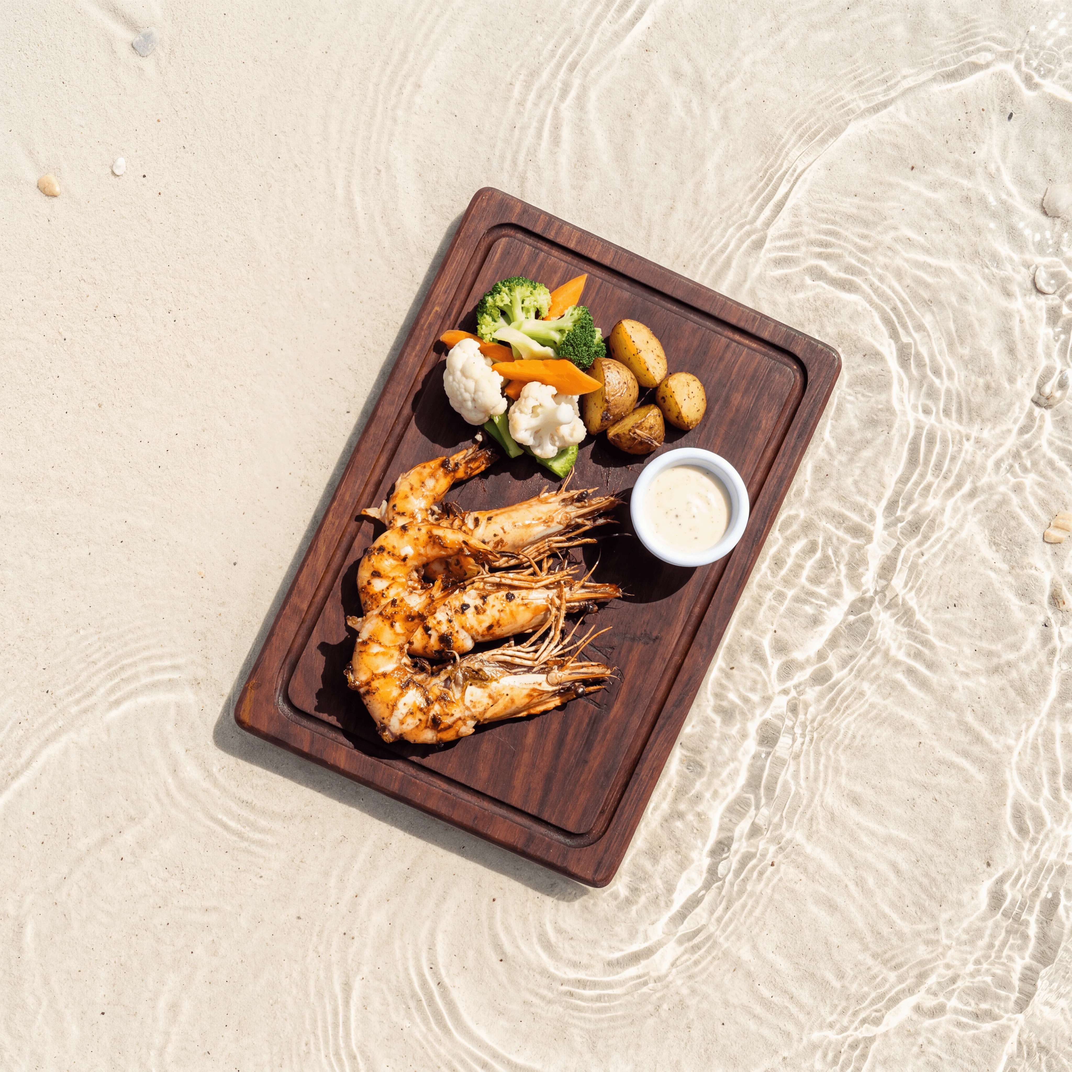Charcoal-grilled tiger prawns with sambal matah on stoneware — beachside resort seafood photography