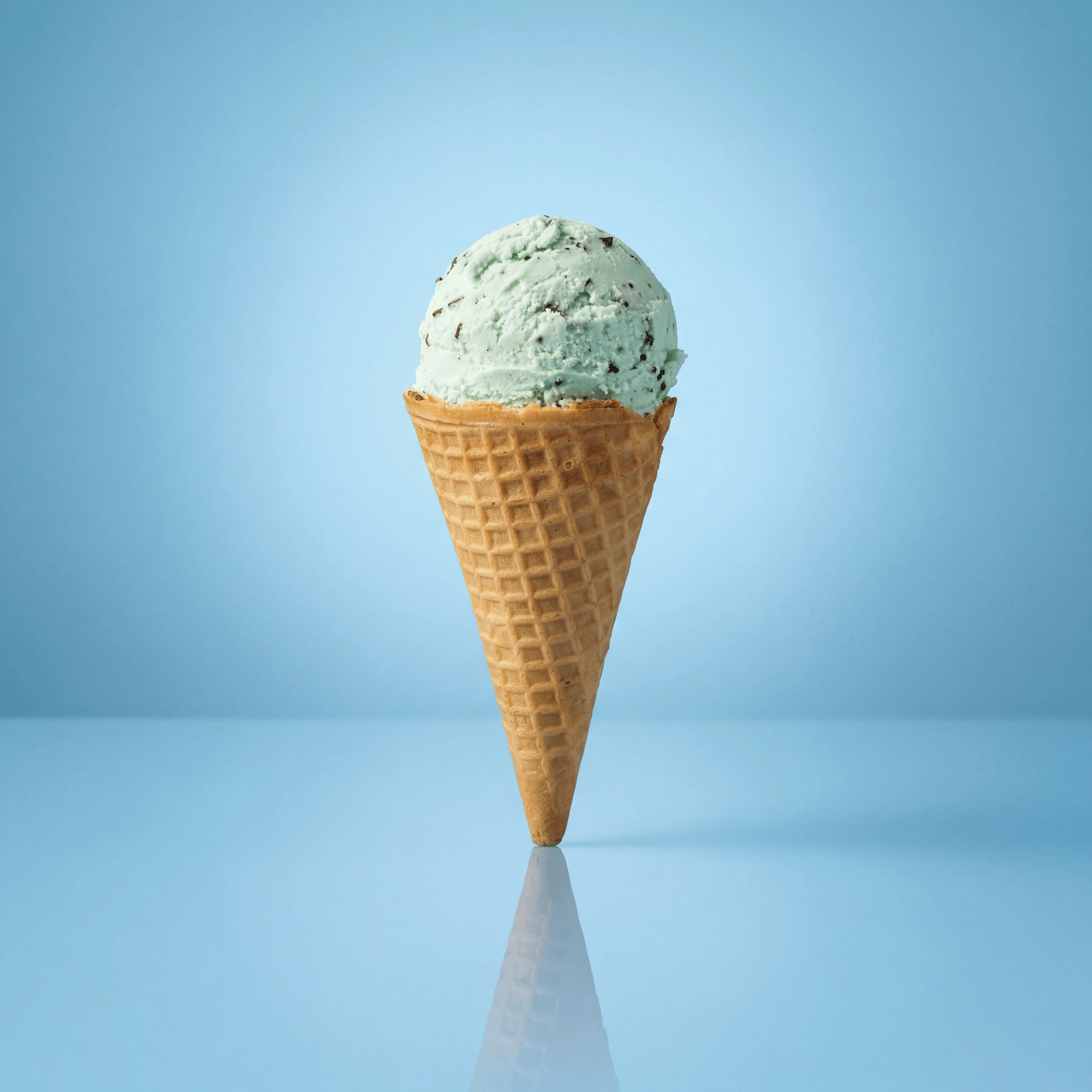 Mint chocolate chip ice cream waffle cone solo scoop — clean cone presentation card photography