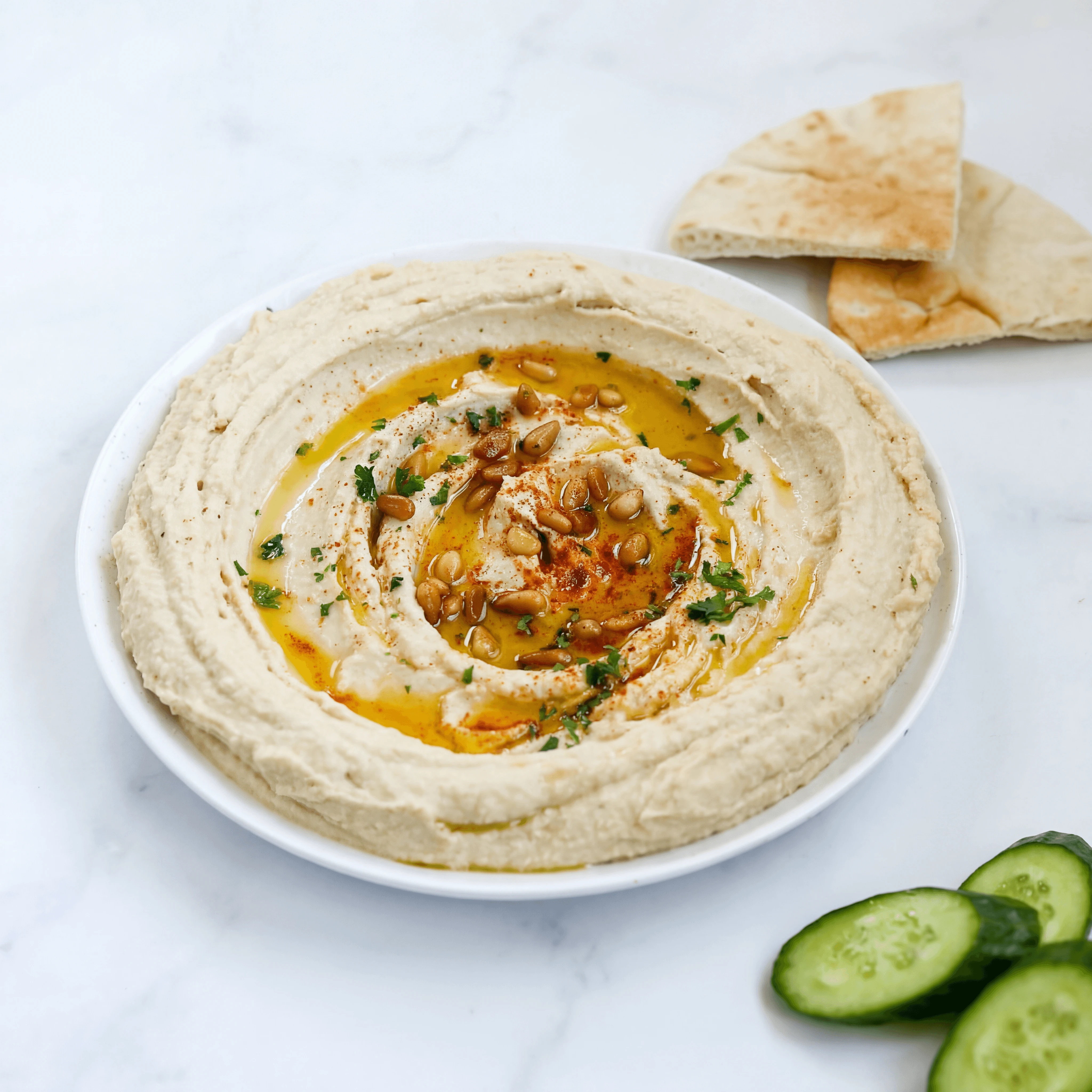 Single hummus bowl swirl paprika olive oil parsley pita — hummus hero photography