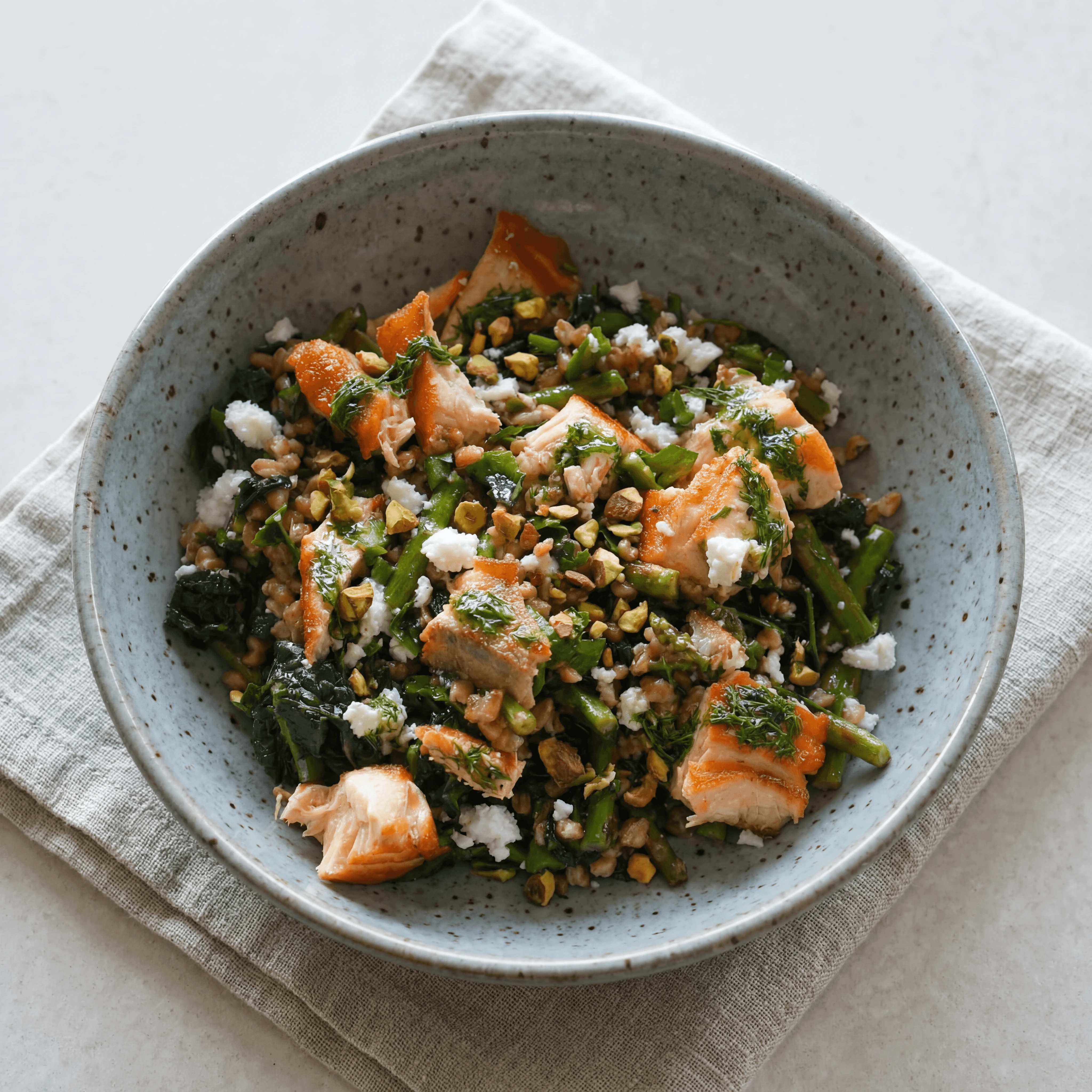 Mediterranean wellness bowl salmon greens farro avocado nuts overhead marble — wellness bowl hero photography