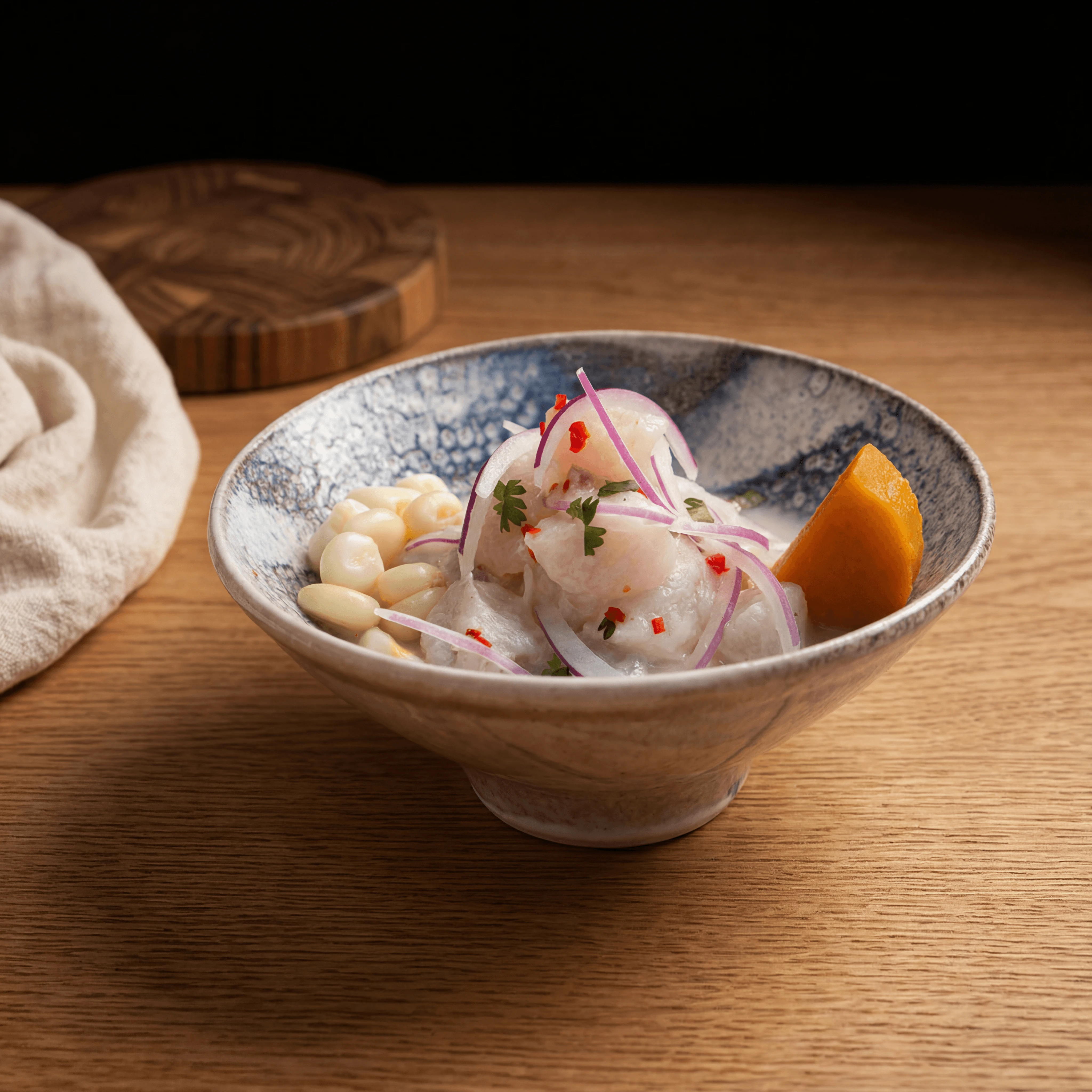 Single ceviche bowl close up macro leche de tigre red onion cilantro slate — iconic ceviche FAQ sidebar photography