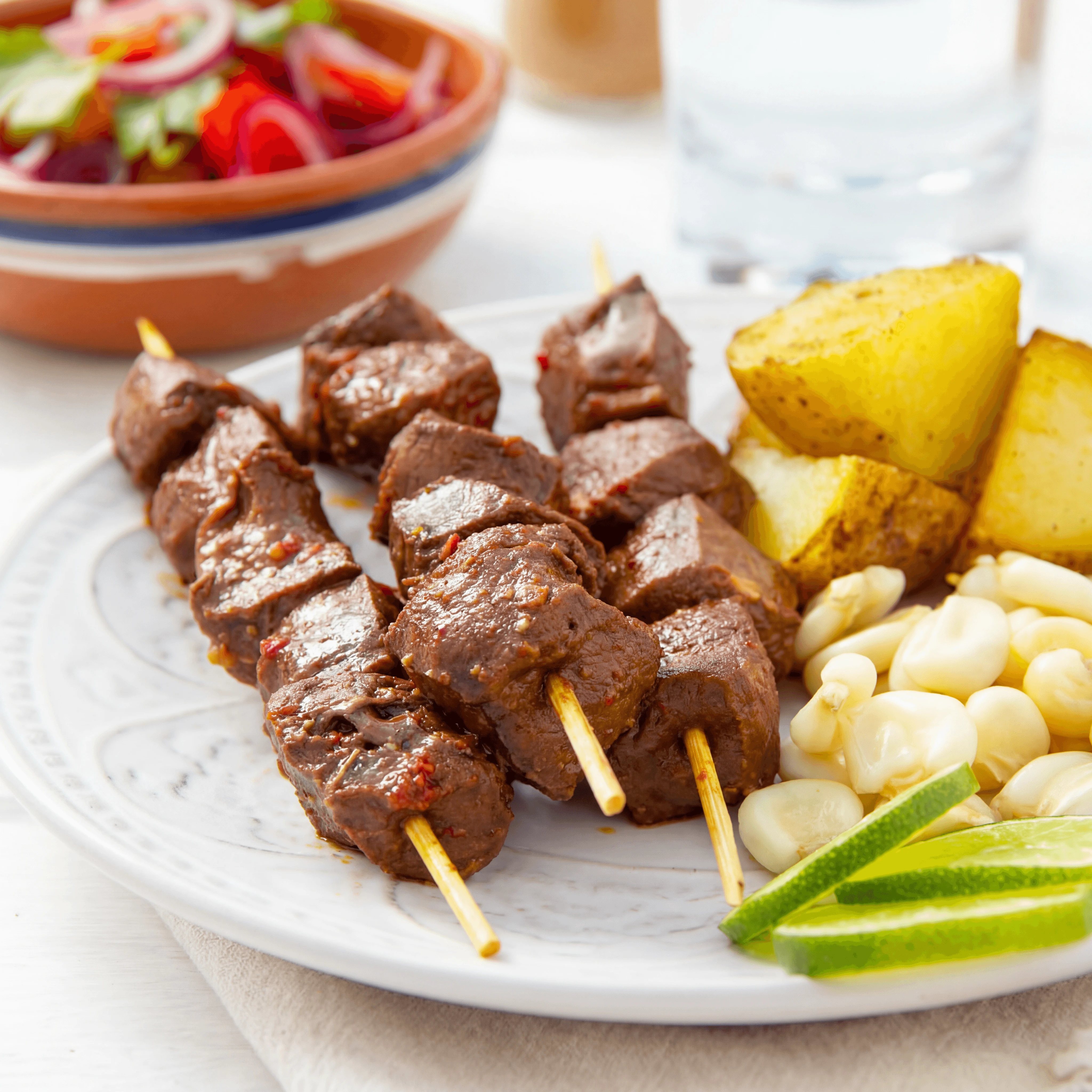 Anticuchos beef heart skewers char rocoto chili glaze plate — anticuchos hero photography