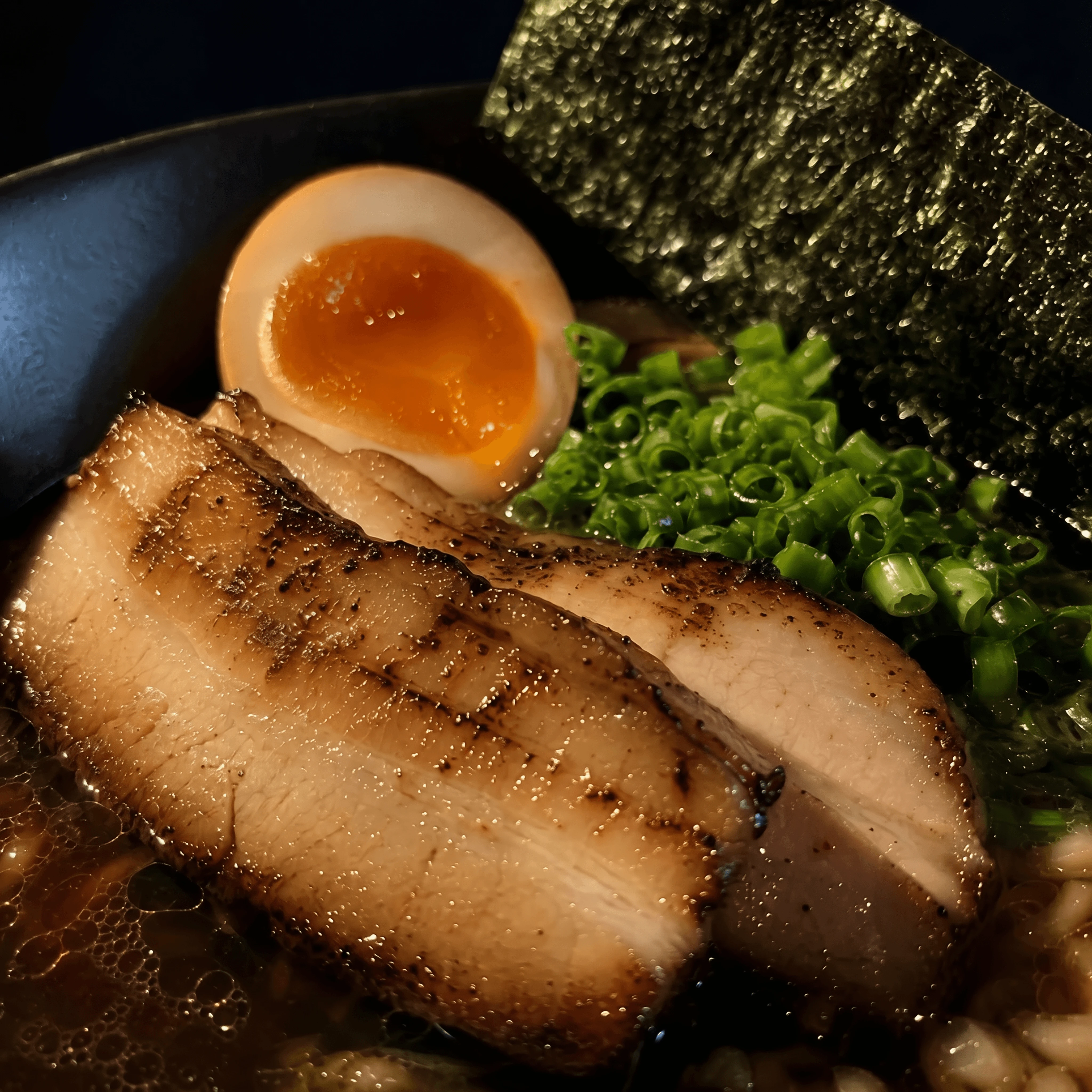 Chashu pork ajitama egg nori topping macro layered ramen — ramen toppings hero photography