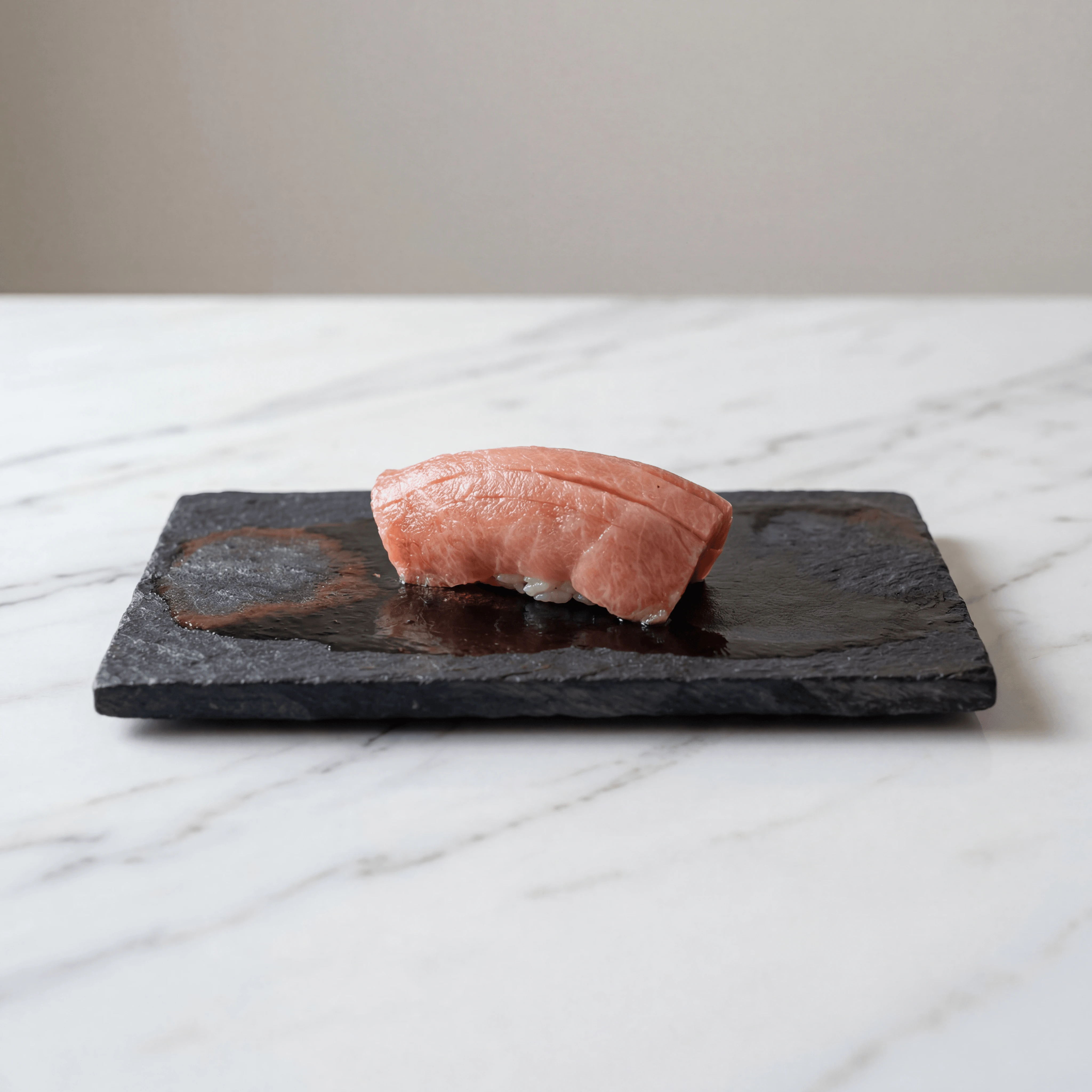 Single otoro nigiri macro slate plate brush nikiri glaze — iconic sushi FAQ sidebar photography