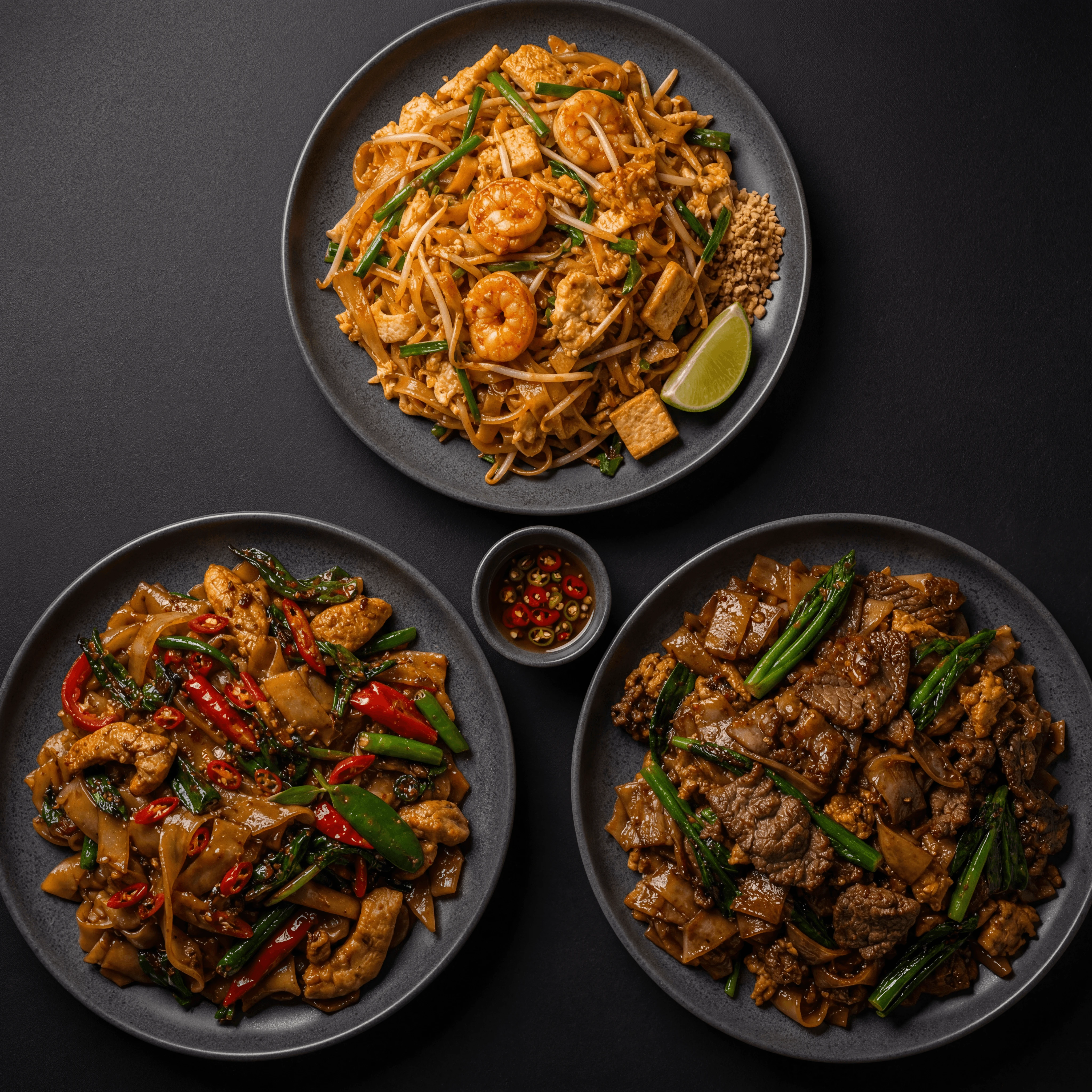 Thai stir-fry noodles pad thai drunken noodles pad see ew trio overhead dark monolith — noodles card photography