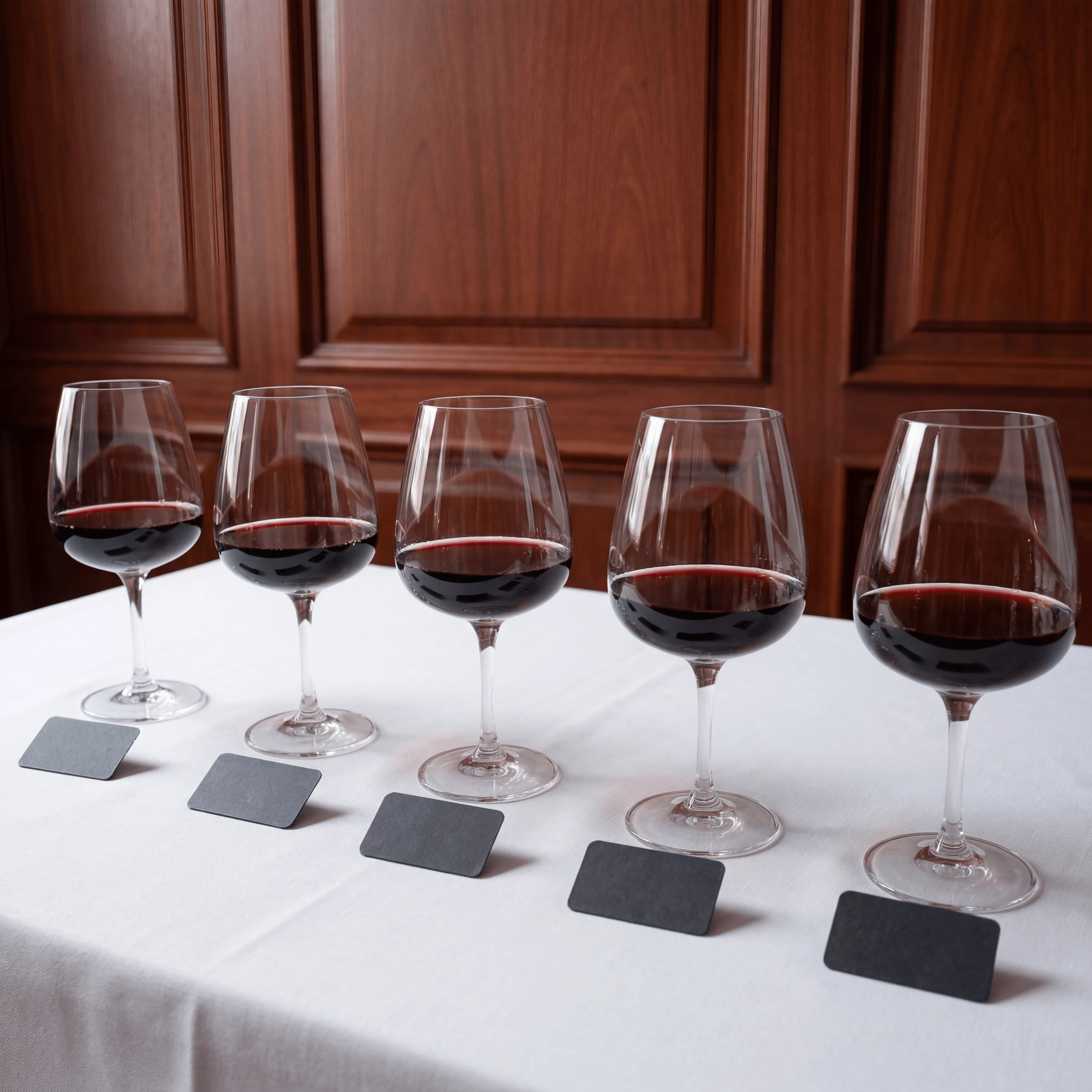 Flight rasa mendatar Bordeaux Left Bank dengan lima gelas classified-growth di atas pelapik linen — fotografi flight wain